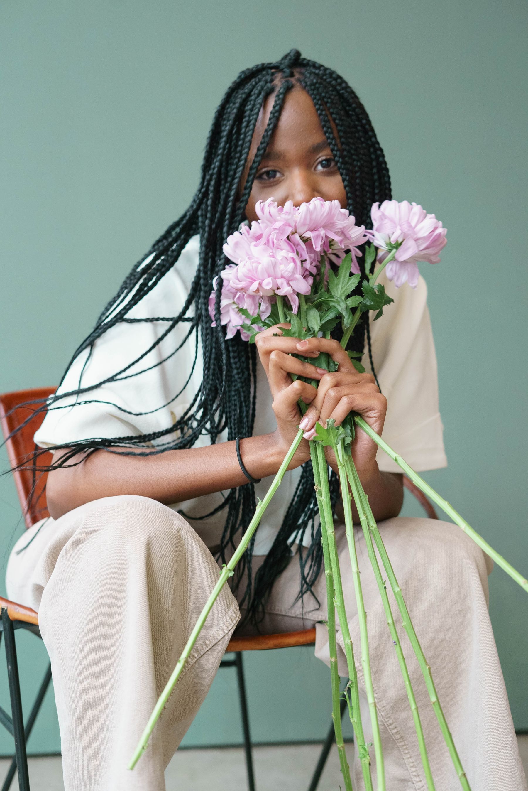 Woman with long braids holding flowers